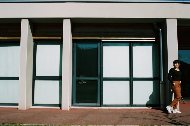 Une comédienne devant un bâtiment