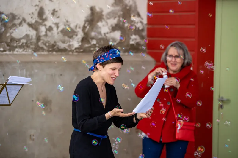 Photo d'une comédienne qui lit, entourée de bulles