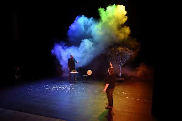 Photo de deux comédiens avec un nuage de fumée arc-en-ciel