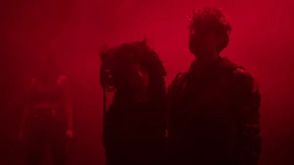 Deux comédiens dans une ambiance lumineuse rouge. 